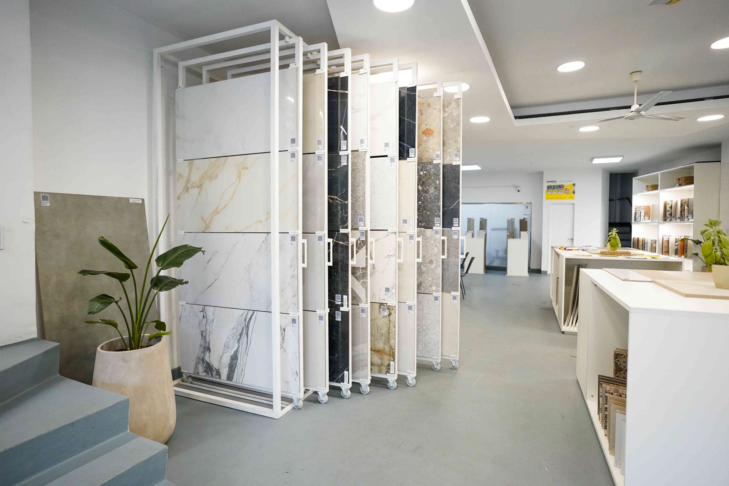 Pasillo del showroom con exhibidores de porcelanatos símil mármol